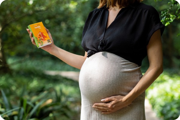 A woman in her seventh month of pregnancy holds the package of a iron deficiency self-test in her hand.