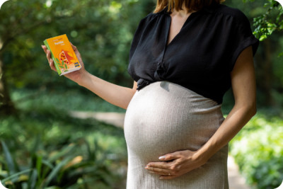 A woman in her seventh month of pregnancy holds the package of a iron deficiency self-test in her hand.