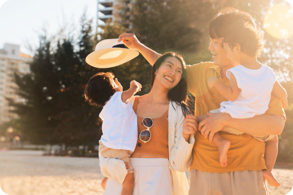 A family with two children is enjoying the sun on the beach during their summer vacation to get some vitamin D.